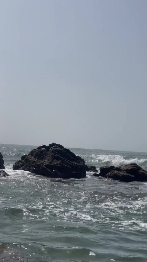 Vertical Close Up of Ocean Water Churning Around Black Rocks Stock Footage 340775103