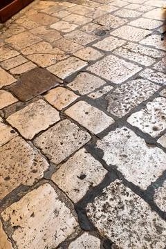Vertical close up of old stone pavement with square cobblestone blocks and Stock Photos