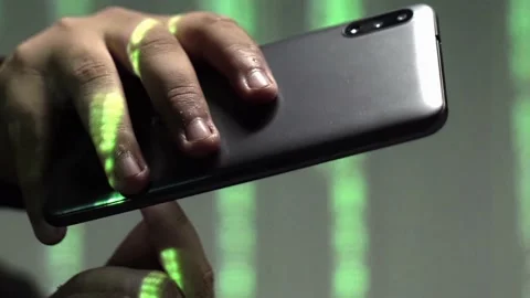 Vertical close-up of phone in hands with rolling green text behind Stock Footage 236917943