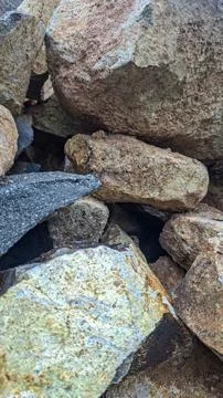 Vertical close up of a pile of rough natural stones texture background Stock Photos