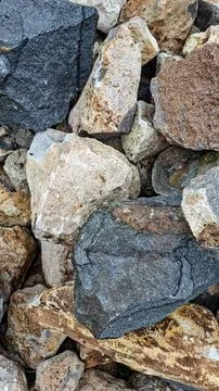 Vertical close up of a pile of rough natural stones and rocks texture Stock Photos