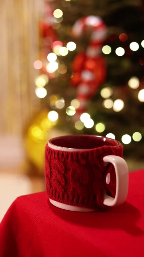 A Vertical Close Up Of A Red Mug With Knit Sweater On Holiday Table Stock Footage 313707912