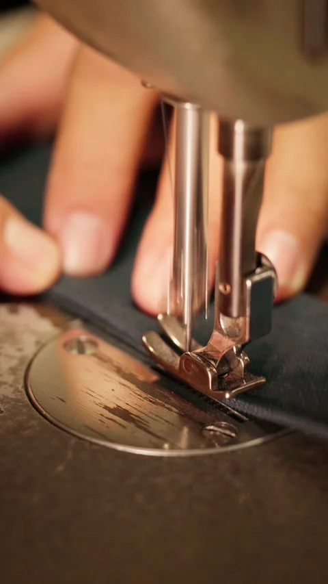 Vertical close-up of a sewing machine needle and presser foot stitching alo.. Stock Footage 342582865