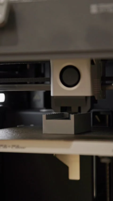 A vertical, close-up shot of a 3D printer extruder head actively depositing Stock Footage 333933123