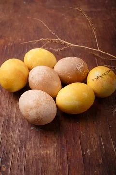 Vertical close up shot of colored easter eggs on brown rustic table Stock Photos