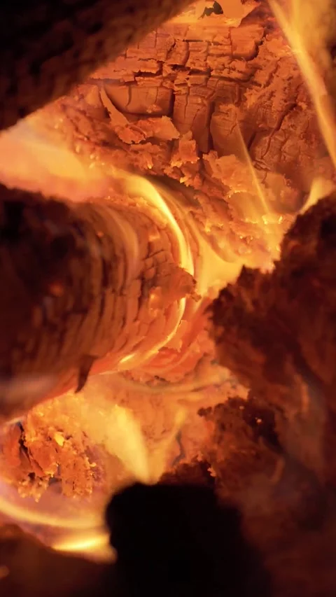 Vertical close-up shot of glowing orange flames flickering between burning Stock Footage 339678309