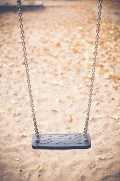 Vertical close shot of a swing with a blurred background at daytime Stock Photos