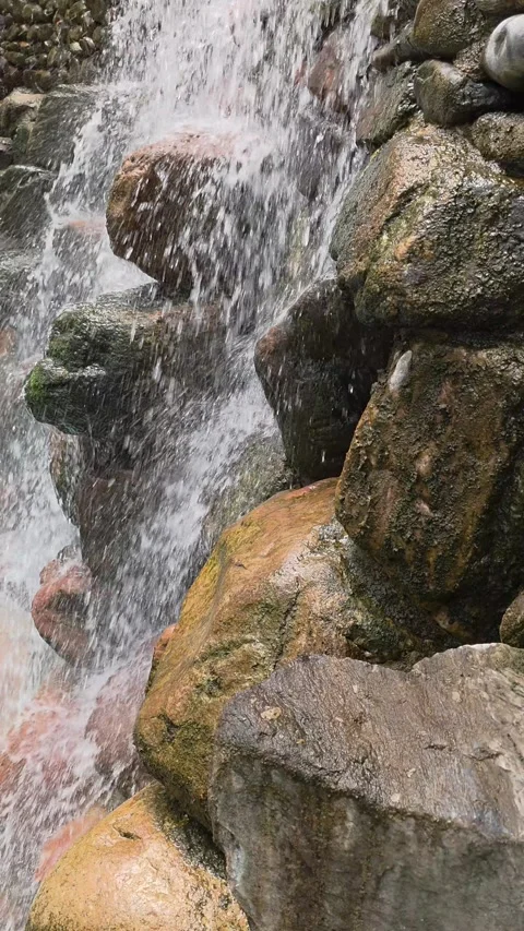 Vertical close-up shot of a waterfall cascading over stacked rocks Stock Footage 312362207