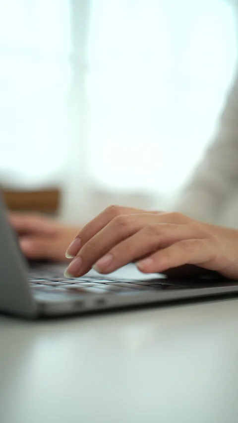 Vertical close up shot of woman's hand typing on laptop keyboard while sitting. Video stock 285523674