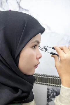 Vertical close-up side profile of a young Asian Muslim woman in a hijab usi.. Stock Photos