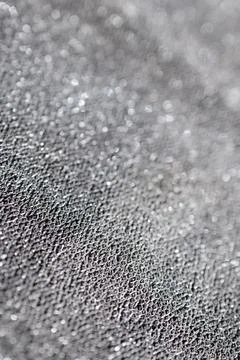 Vertical close-up of silver metallic glitter background out of focus. Stock Photos