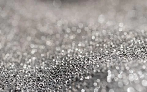 Vertical close-up of silver metallic mesh with blurs. Stock Photos