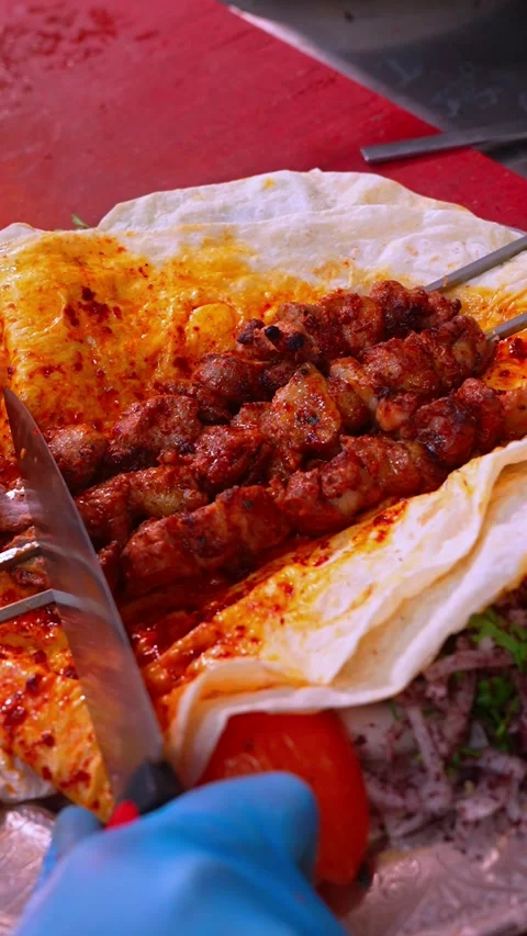 Vertical Close Up Slicing Lamb Kebab off Skewer onto Thin Lavash Bread for .. Stock Footage 332554906