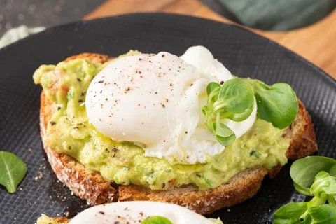 Vertical close up of a soft poached egg with a vibrant golden yolk flowing .. Foto stock