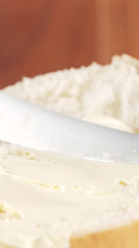 Vertical Close-Up Spreading Butter on Soft Bun Half  Slow Motion Food Clip .. Stock Footage 312169102