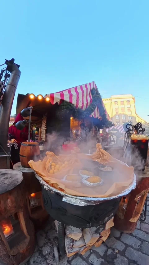 Vertical close-up of steaming hot quince cider simmering over open fire at Riga Stock Footage 328613227