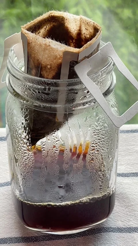 Vertical close up of steaming pour over coffee dripping from filter bag into  Stock Footage 272158058