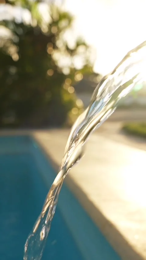 Vertical Close up stream of water flowing from a green hose and filling a clean Stock Footage 316459502