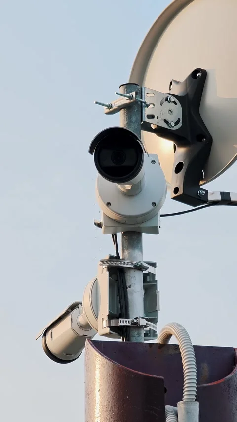 Vertical close-up of a surveillance camera and network antenna. Urban video Stock Footage 329304276