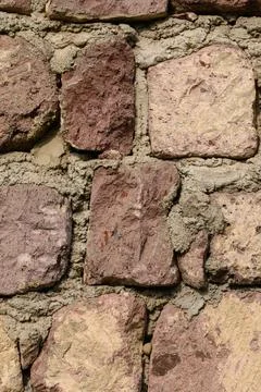 Vertical close-up texture of a rustic stone and mortar wall Stock Photos