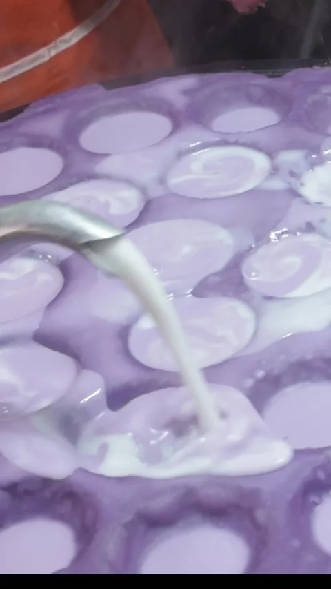 Vertical Close-Up of Thai Coconut Pancake Batter Being Poured into Hot Mold Stock Footage 328213724