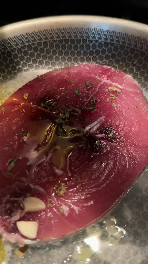 Vertical Close Up of Tuna Steak with Garlic Cooking in Frying Pan Stock Footage 315089950