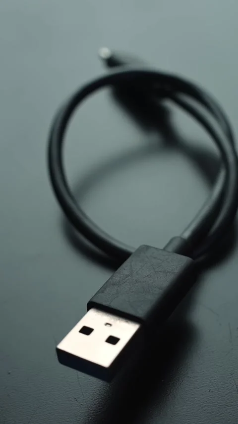 Vertical close-up of USB 3 to USB-C cable on a gray desk with soft bokeh and Stock Footage 329471487