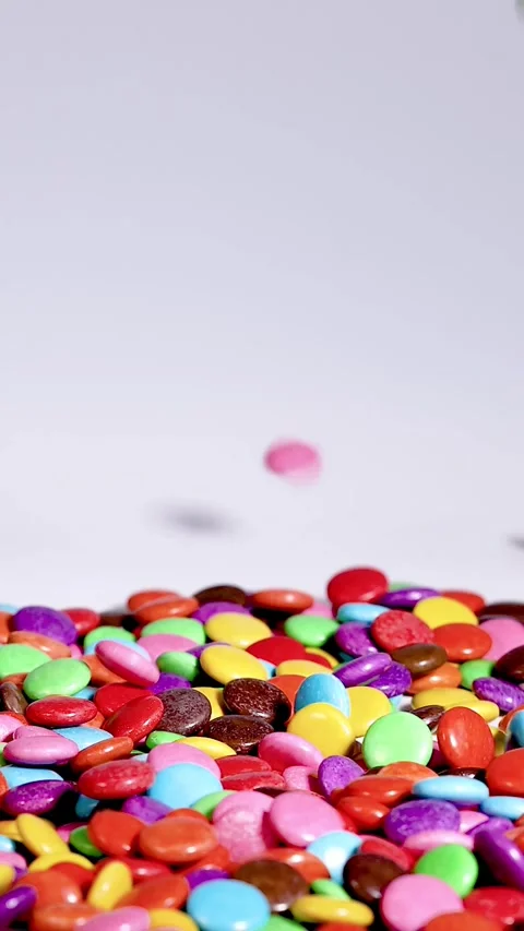 Vertical Close Up of Vibrant Candy Pieces Falling into Pile Stock Footage 331899070
