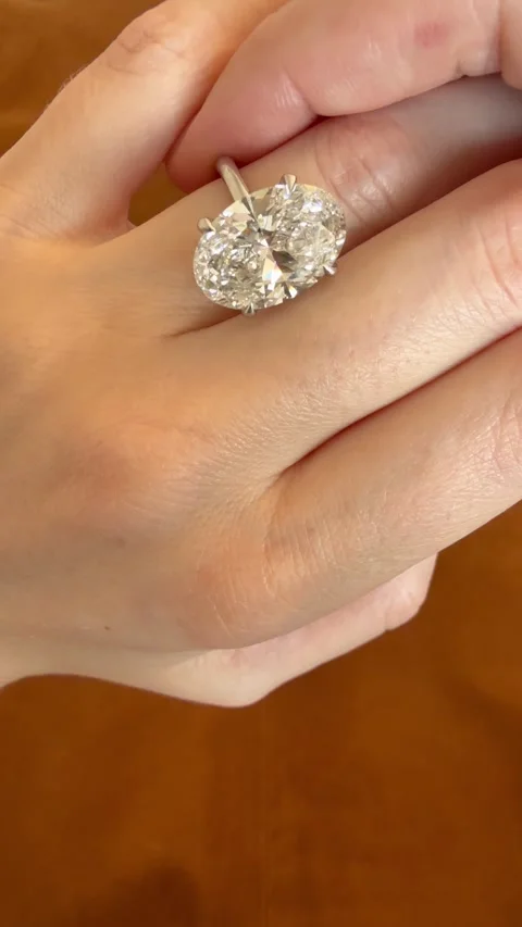 Vertical close up video highlighting a luxury oval diamond engagement ring Stock Footage 314786712