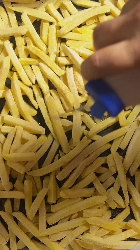 Vertical close up video. Man sprinkles salt on French fries Video stock 286181878