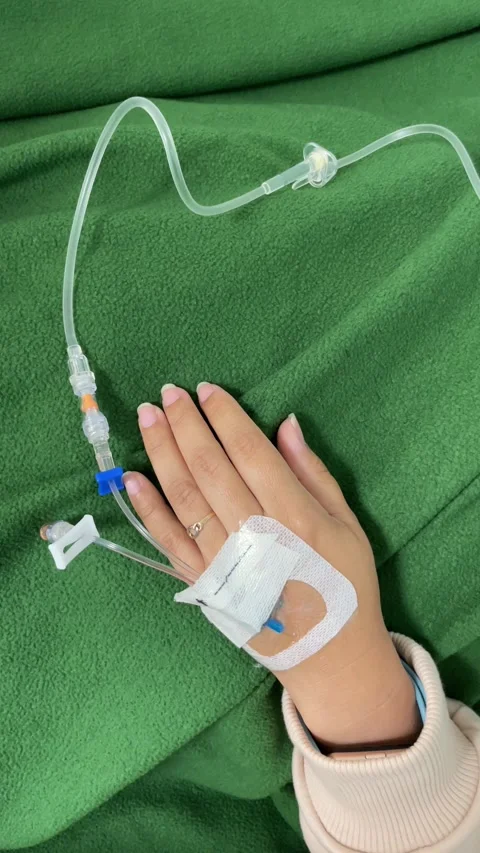 Vertical close-up video of a patient's hand receiving an intravenous (IV) dri Stock Footage 297966655