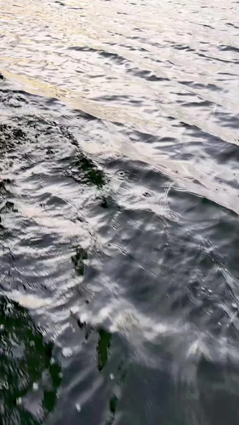 Vertical close up video of rippling water wakes behind a boat cruising on Lake Stock Footage 340920816