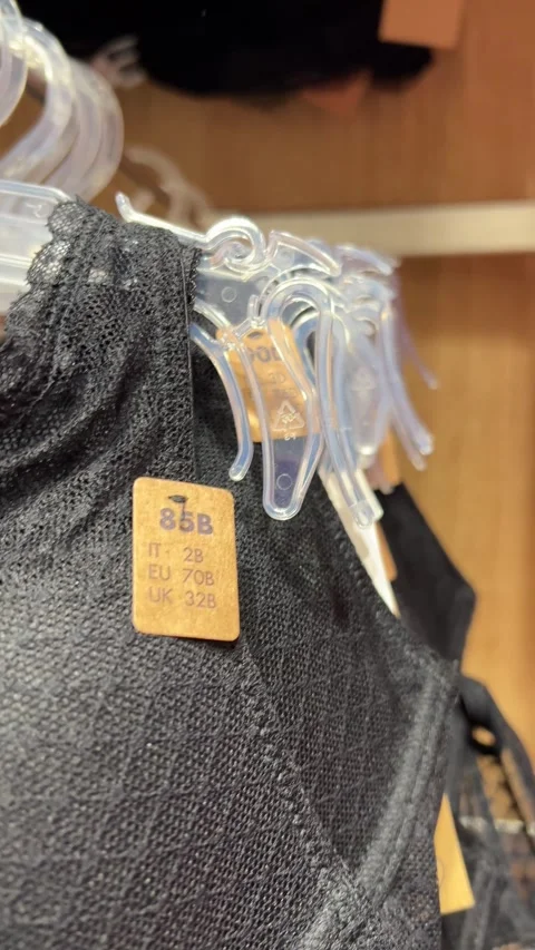 Vertical close up video. Tag with 100 C sign on black bra. EU, RU, IT size Stock Footage 314503392