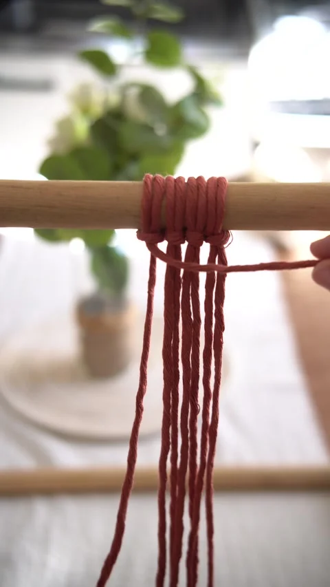 Vertical close-up video of a woman’s hands making macramé knots. Handmade craft  Stock Footage 346326117