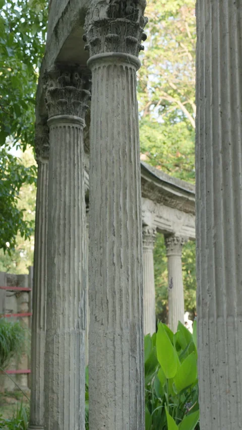 Vertical Close Up View of Ancient Corinthian Stone Columns with Lush Park Greene Stock Footage 340477156