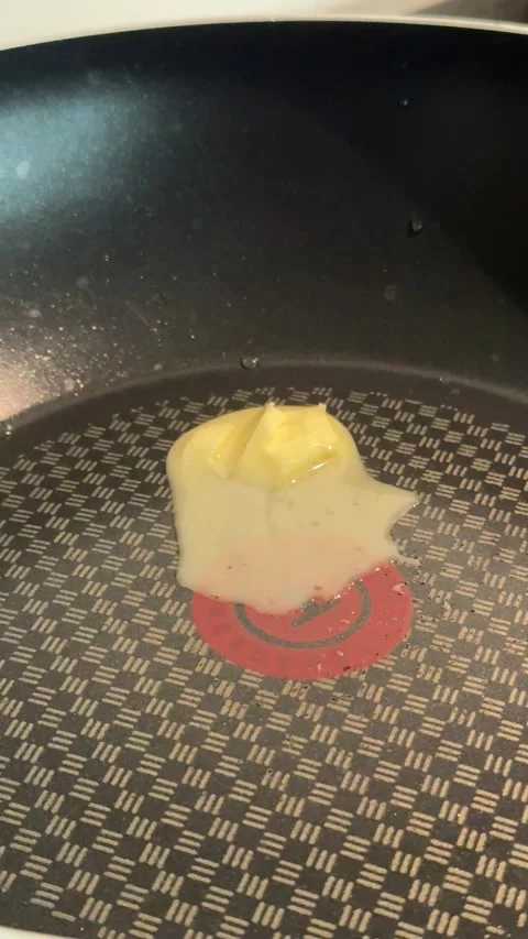Vertical Close Up View Of Butter Cube Melting On Hot Metal Frying Pan Surface Stock-Footage 346596753