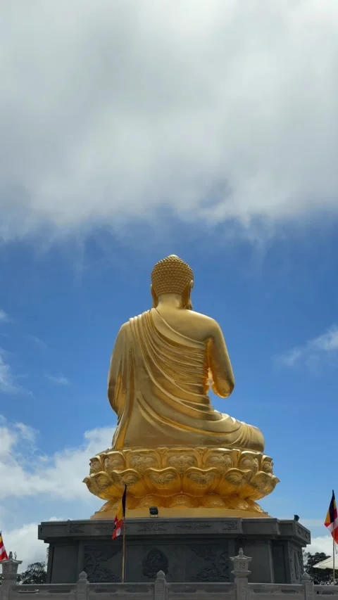 Vertical close view of a golden Buddha statue with Vitarka mudra raised hand 库存影片 329304437