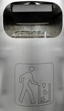 Vertical close up view of a silver metal trash can with litter symbol Stock Photos