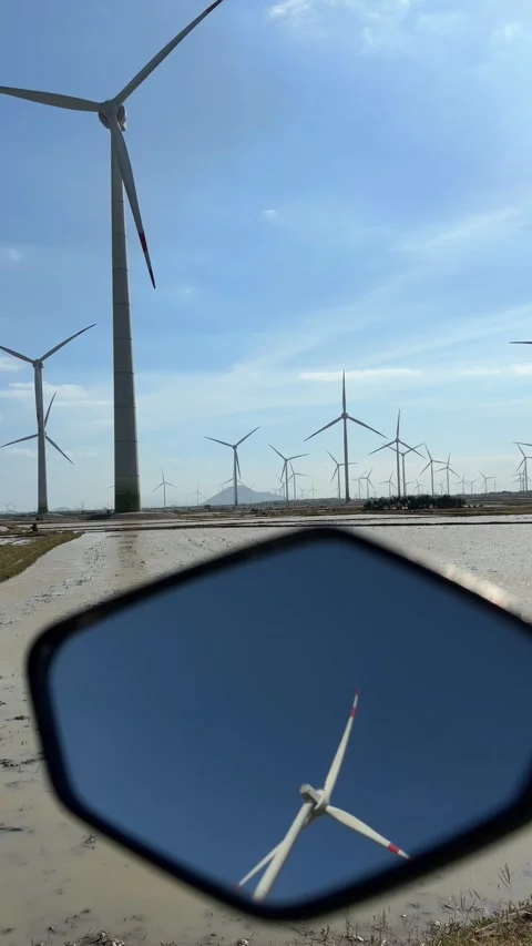 Vertical close view of the upper part of a wind turbine rotating against a Video stock 328097107