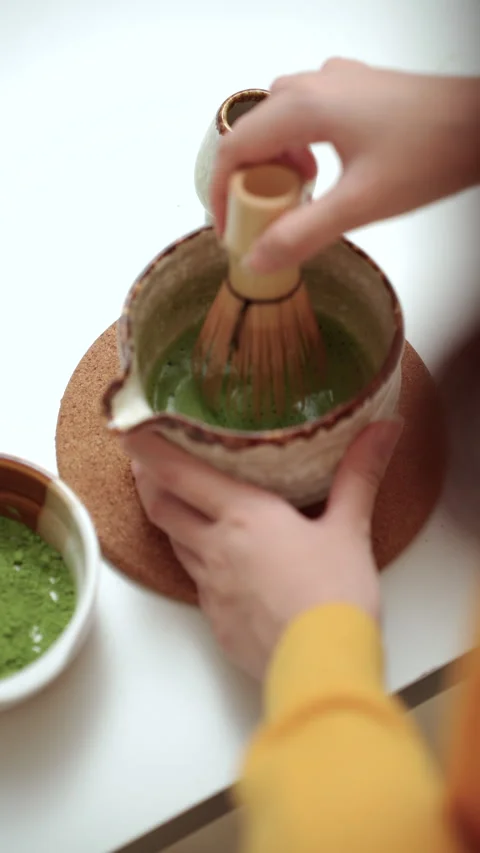 Vertical close up woman's hand making green tea matcha using bamboo natural Stock-Footage 338988201