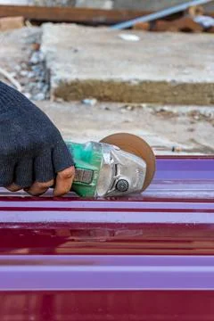 Vertical Close-Up of Worker Hand Cutting Metal Sheet with Grinder Stock Photos