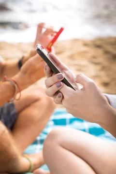 Vertical close up of young couple using smartphone app outdoors. Stock Photos