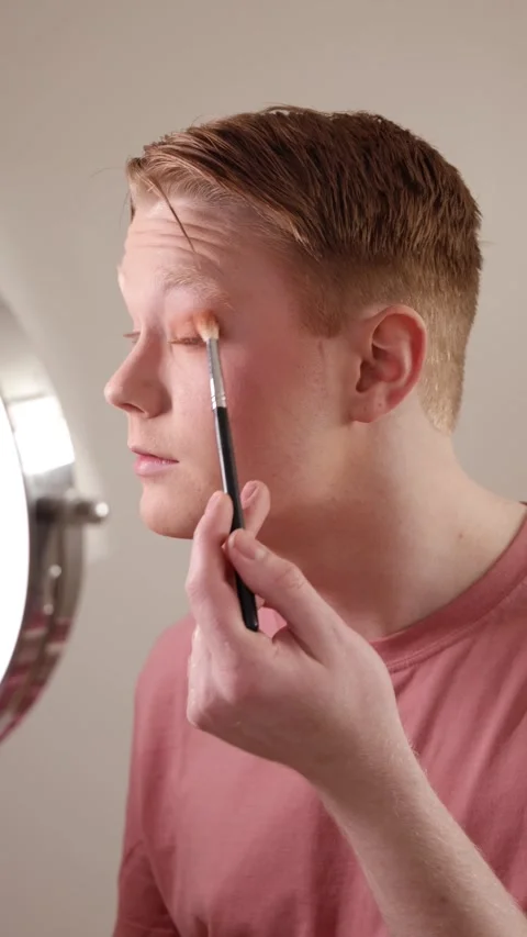 A Vertical Close-up of A Young Man Applying Eyeshadow in Front of Mirror Stock Footage 310161510