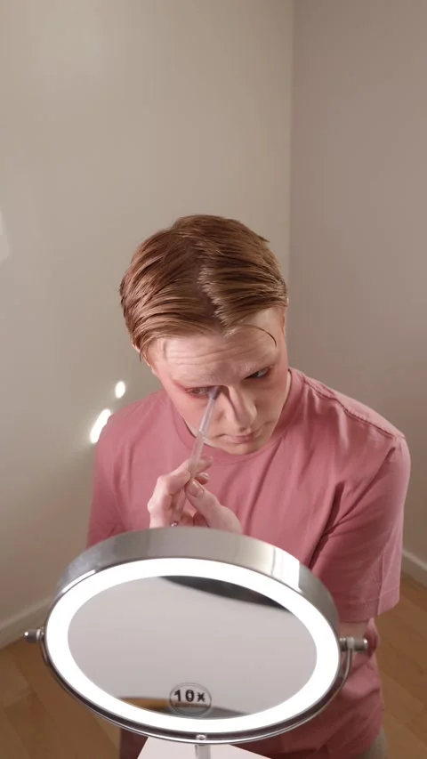 A Vertical Close-up of A Young Man Applying Eyeshadow in Front of Mirror Stock Footage 310162298
