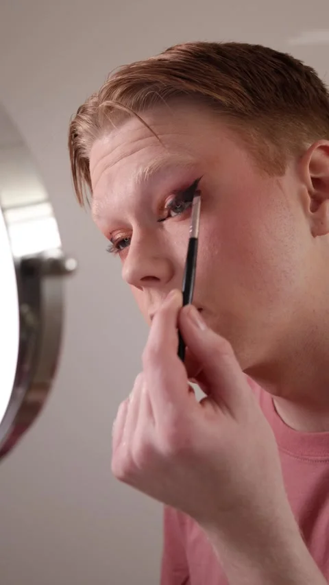 A Vertical Close-up of A Young Man Applying Eyeshadow in Front of Mirror Stock Footage 310221399