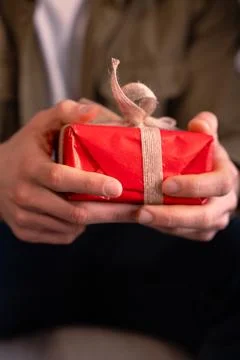Vertical .Close-up The young man opens a gift that his partner gives him. Foto stock
