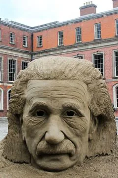 Vertical closeup of Albert Einstein's bust with Dublin castle in the background Stock Photos