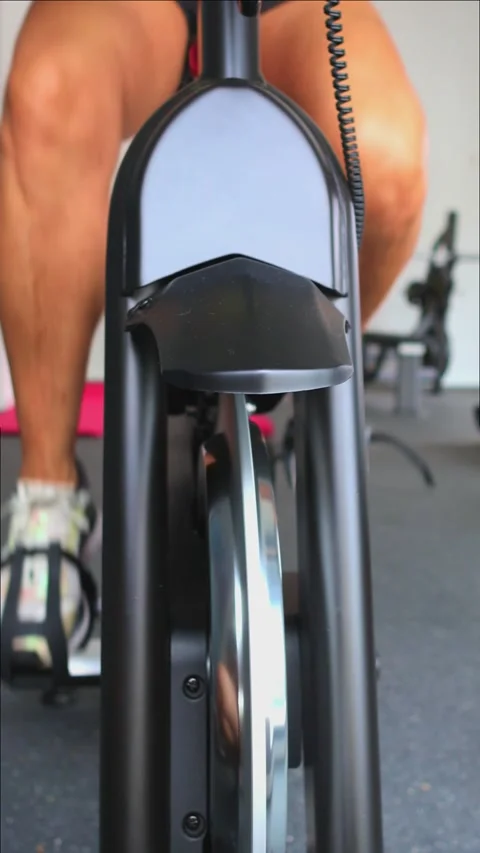 Vertical Closeup elderly athletic womans legs pedaling on gym spinning bike.. Stock Footage 285092416