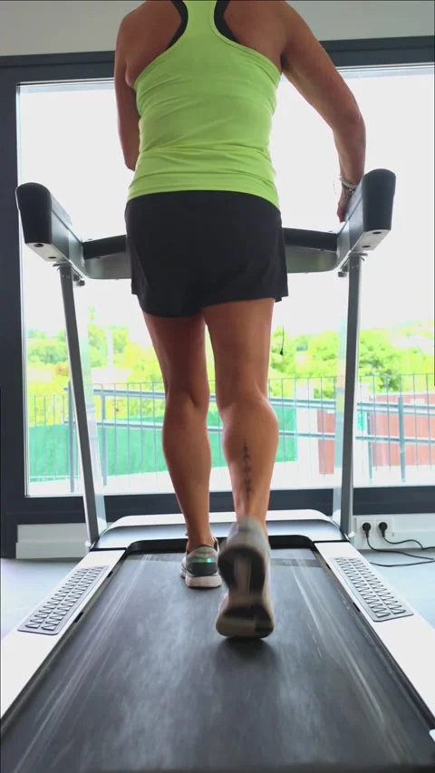 Vertical Closeup elderly female athletes tattooed legs walking on treadmill.. Stock Footage 285092413