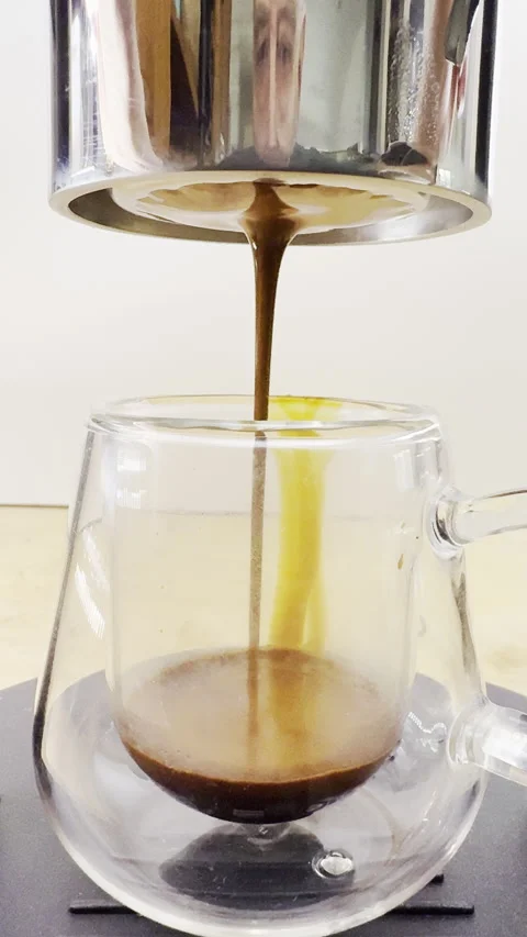 Vertical - Closeup of espresso coffee starting to be delivered into a glass cup. Stock Footage 302366979